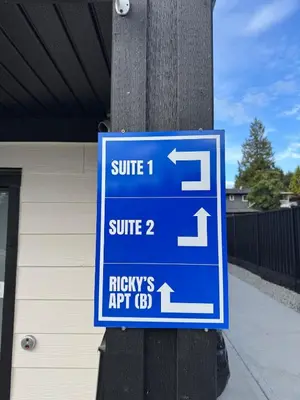 a blue sign on a pole next to a building at Brand new fully private Garden Suite 1 in Delta