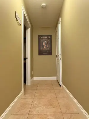 a hallway with a tile floor and a picture on the wall at A Room of One's Own-A perfect getaway by the sea in North Nanaimo in Nanaimo