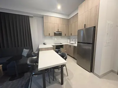 a kitchen with a refrigerator and a table and chairs at La Quinta Inn & Suites by Wyndham Kelowna BC in Kelowna