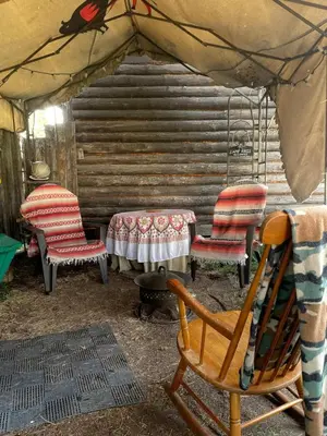 a group of chairs and a table in a tent at Cozy Country Log Cabin Art Spa Getaway in Caroline