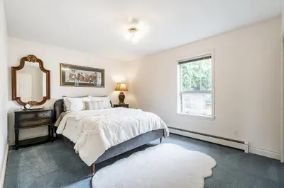 a bedroom with a bed and a mirror and a window at Surrey Nature Retreat 4BDR Home in Surrey