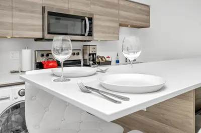 a kitchen with two wine glasses on a counter at Vita Resort Vernon - Modern Studio on Okanagan Lake in Vernon