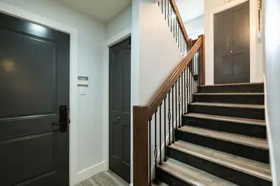 a hallway with black doors and stairs at Englewood Greens 40 by Outpost Whistler in Whistler