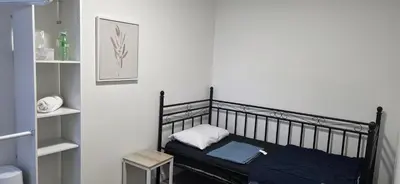 a black bed in a room with a shelf at Single Court in Abbotsford