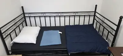 a black bed with two pillows on it at Single Court in Abbotsford
