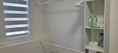 a bathroom with a window and a shelf with bottles at Single Court in Abbotsford