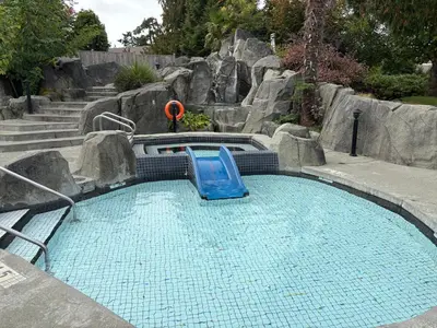 a small swimming pool with a slide in a garden at Oceanside Getaway in Nanoose Bay