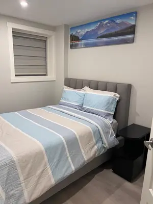 a bedroom with a bed with blue and white sheets at The Lakefront - A new 2-bedroom in Mahogany Calgary in Calgary