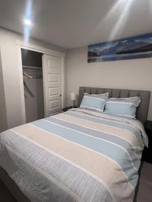 a bedroom with a large bed and a closet at The Lakefront - A new 2-bedroom in Mahogany Calgary in Calgary