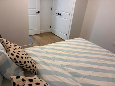 a bedroom with a bed with a striped comforter at Home away from Home in Edmonton