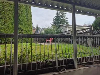 a fence in front of a yard with a house at Enjoy Life in Heart of North Delta in Delta