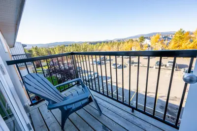 a blue chair sitting on a balcony with a view at Bearberry Premium Rentals in Whitehorse