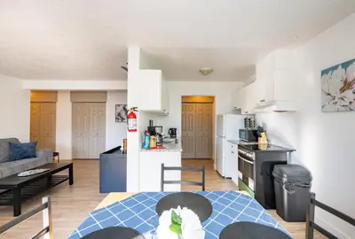 a kitchen and a living room with a table at Bearberry Premium Rentals in Whitehorse
