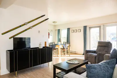 a living room with a couch and a tv at Bearberry Premium Rentals in Whitehorse
