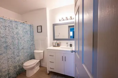 a bathroom with a toilet and a sink and a mirror at Bearberry Premium Rentals in Whitehorse