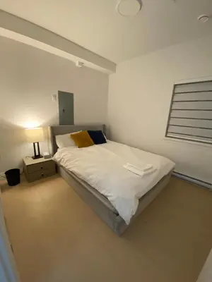 a bedroom with a bed and a lamp in it at Sunshine A in Vancouver