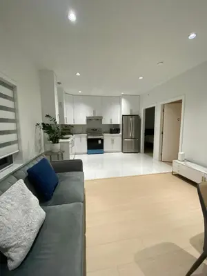 a living room with a couch and a kitchen at Sunshine A in Vancouver