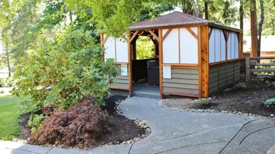 a gazebo in a garden with a tree at Saratoga beach cabin with hot tub in Oyster Bay