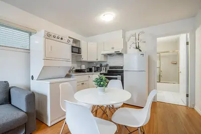 a kitchen with a white table and chairs in a room at Private Guest Suite with Kitchen in Vancouver
