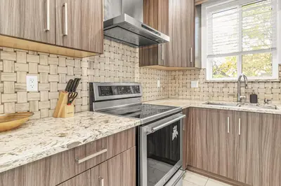 a kitchen with wooden cabinets and a stove top oven at 8BR New Spacious Home White Rock HVAC Free Parking in Surrey