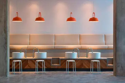 a waiting room with three sinks and three stools at Residence Inn by Marriott Calgary South in Calgary