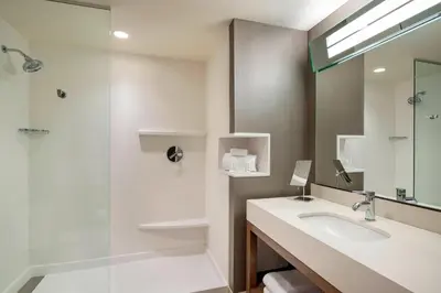 a bathroom with a sink and a shower at Courtyard by Marriott Calgary South in Calgary
