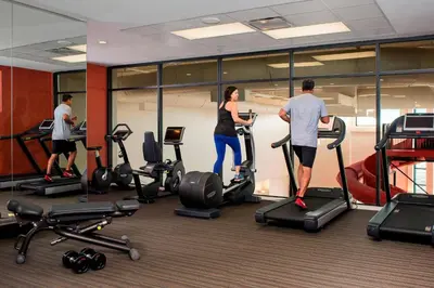 a group of people exercising on exercise bikes in a gym at Courtyard by Marriott Calgary South in Calgary