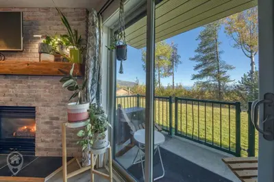 a screened in porch with a fireplace and a view at InnWest by StayIn in Kimberley