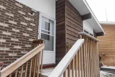 a house with a white door and a brick wall at Mi Light House \u7c73\u62c9 in Yellowknife
