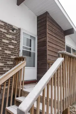 a house with a porch and a white door at Mi Light House \u7c73\u62c9 in Yellowknife