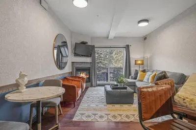 a living room with a couch and a table at Amazing Views 1BR Condo with Hot Tub and Pool in Canmore