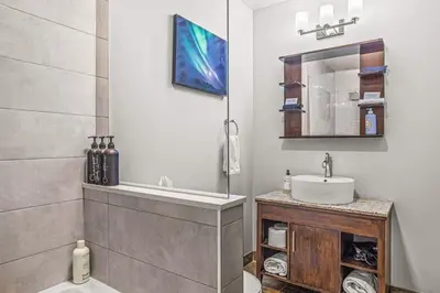 a bathroom with a sink and a mirror at 2BR Scenic Rockies Retreat BBQ Hot Tub and Pool in Canmore
