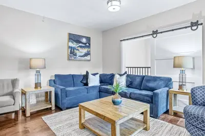 a living room with blue couches and a table at Mountain View Penthouse 3BR with Private Hot Tub in Canmore