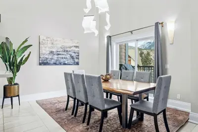 a dining room with a wooden table and chairs at Mountain View Penthouse 3BR with Private Hot Tub in Canmore