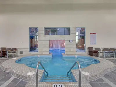 a large swimming pool in a building with stairs in it at Mountain View Penthouse 3BR with Private Hot Tub in Canmore