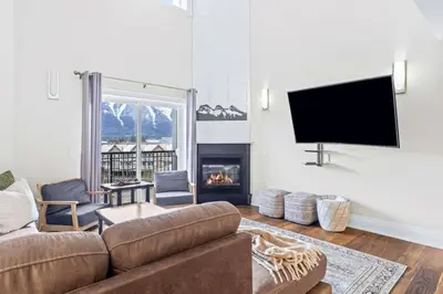 a living room with a couch and a fireplace at Mountain View Penthouse 3BR with Private Hot Tub in Canmore