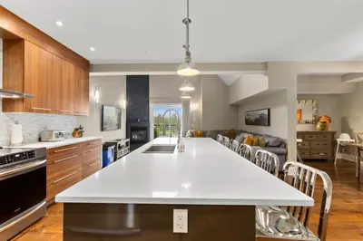 a kitchen with a large white island in a room at LUXUS 4BR Penthouse 2500sqft with Private Hot Tub in Canmore