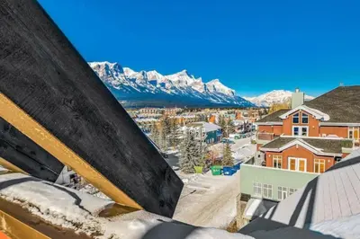 a view of a city with snow covered mountains at LUXUS 4BR Penthouse 2500sqft with Private Hot Tub in Canmore