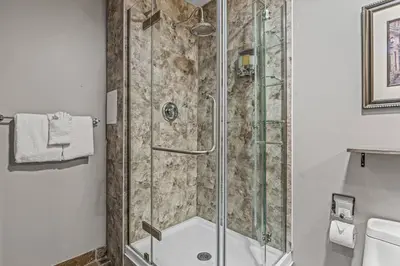 a shower with a glass door in a bathroom at Perfect Rockies Escape with Pool, Hot Tub and Gym in Canmore
