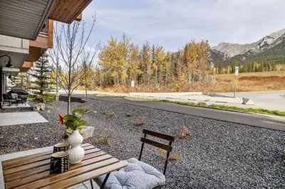 a wooden bench with a vase and a vase at Brand New 1BR Canmore Retreat Hot Tub, Sauna, Gym in Canmore