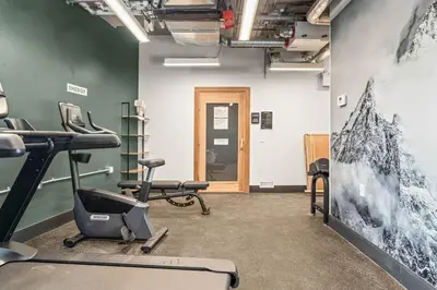 a gym with exercise equipment in a room at Brand New 1BR Canmore Retreat Hot Tub, Sauna, Gym in Canmore