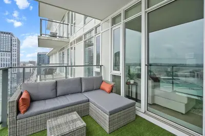 a living room with a couch on a balcony at Downtown Calgary Modern 1BR with Pullout couch in Calgary