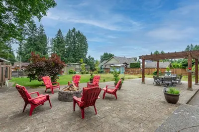 a patio with red chairs and a fire pit at The Wood Shed with hot tub in Oyster Bay