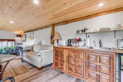 a kitchen and living room with a couch and a table at The Wood Shed with hot tub in Oyster Bay