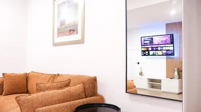 a living room with a couch and a mirror at A true Home away from Home in Calgary