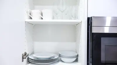 a kitchen with white plates and a microwave at A true Home away from Home in Calgary