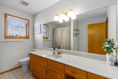 a bathroom with a sink and a toilet and a mirror at Acreage, 3 King Beds and Ensuites, Dance Floor, Fireplace, AC in Calgary