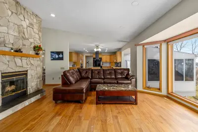 a living room with a leather couch and a fireplace at Acreage, 3 King Beds and Ensuites, Dance Floor, Fireplace, AC in Calgary