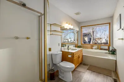 a bathroom with a toilet and a tub and a sink at Acreage, 3 King Beds and Ensuites, Dance Floor, Fireplace, AC in Calgary