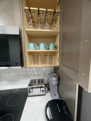 a kitchen with some cups and bowls on shelves at Cozy and modern two bedroom guest suite in Calgary